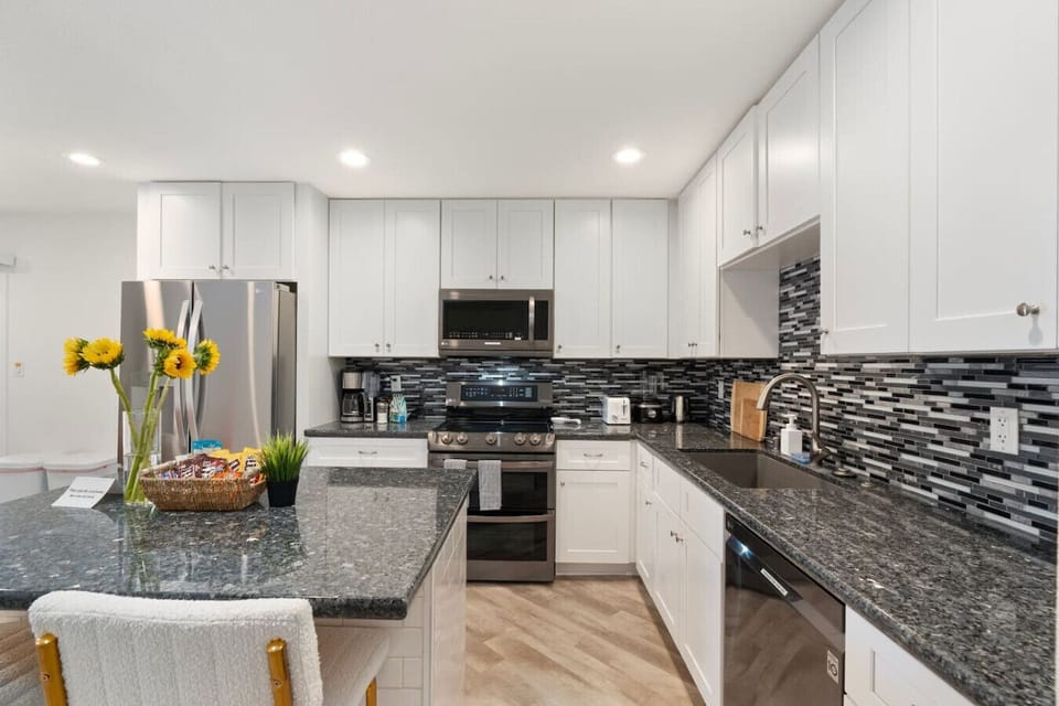Fully equipped kitchen with a spacious island and two cozy bar stools—perfect for cooking, dining, and gathering.