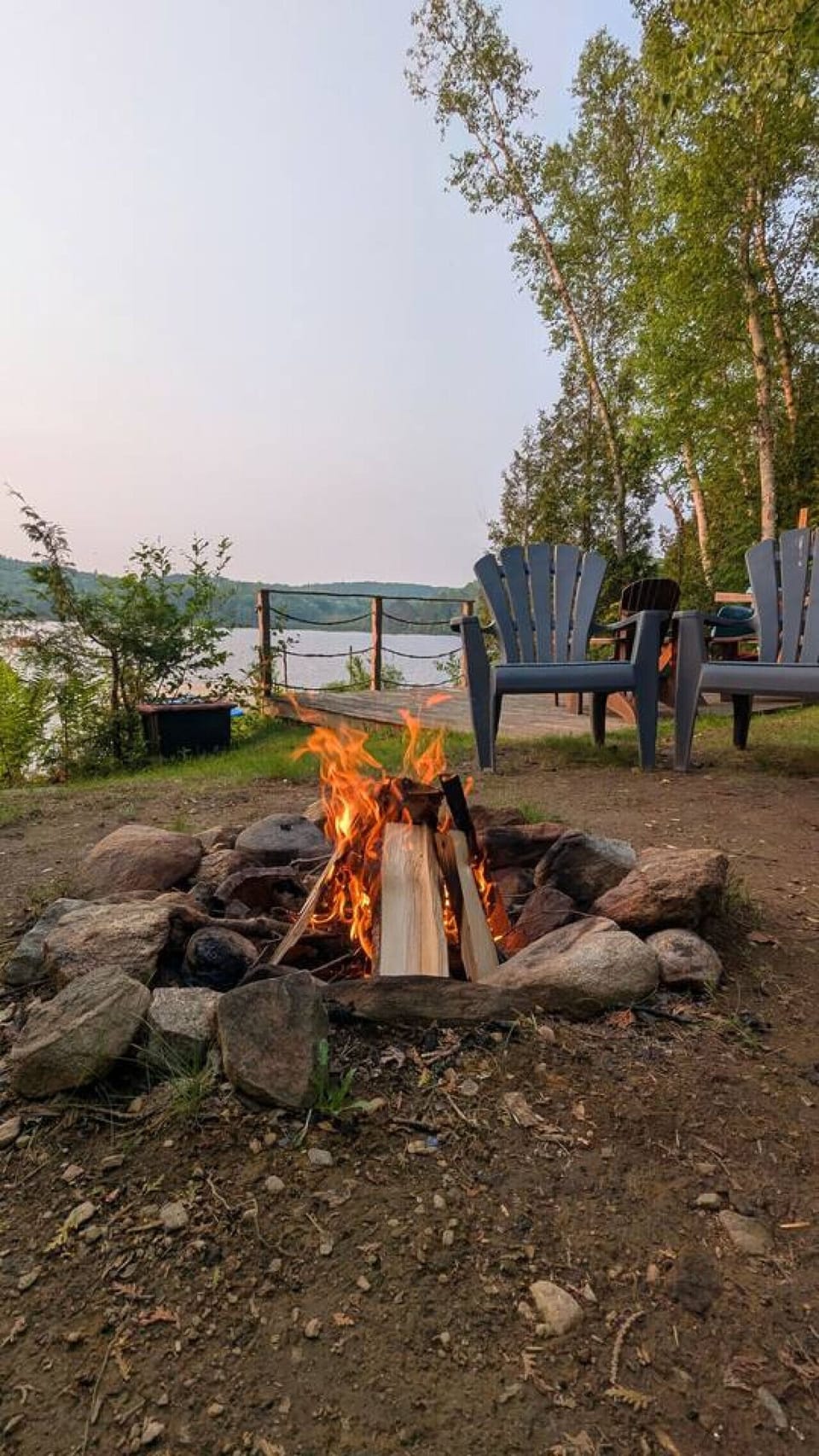 Evening-ready setup with a fire pit and Adirondack chairs for outdoor conversations.