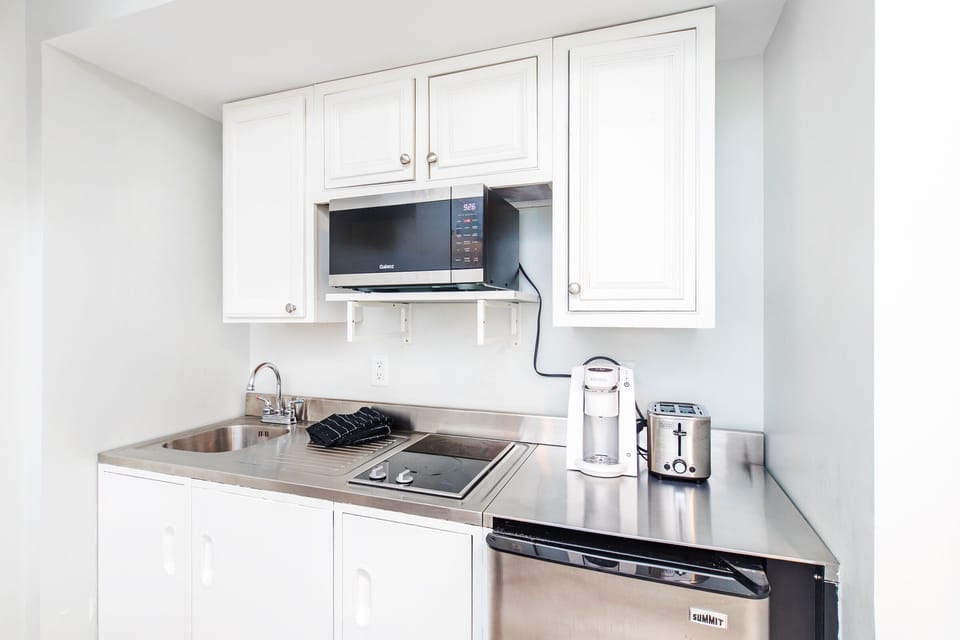 Kitchenette has a microwave, toaster, coffee maker, stove top and min fridge