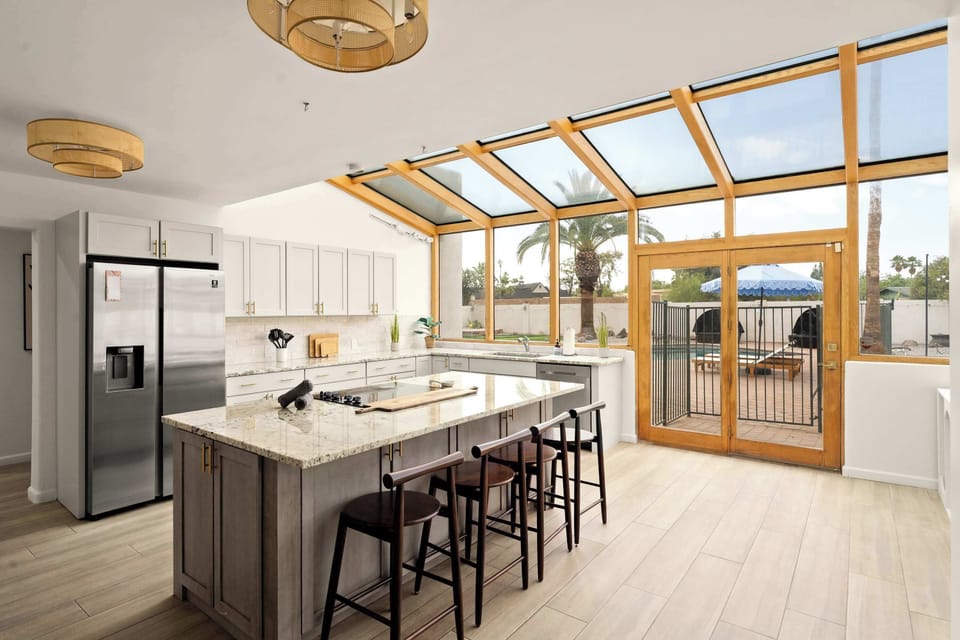 Cook & Gather in Style – Gather around the granite island beneath a stunning glass ceiling, with top-of-the-line appliances and elegant bar seating making this breathtaking sunroom kitchen the heart of every unforgettable gathering.