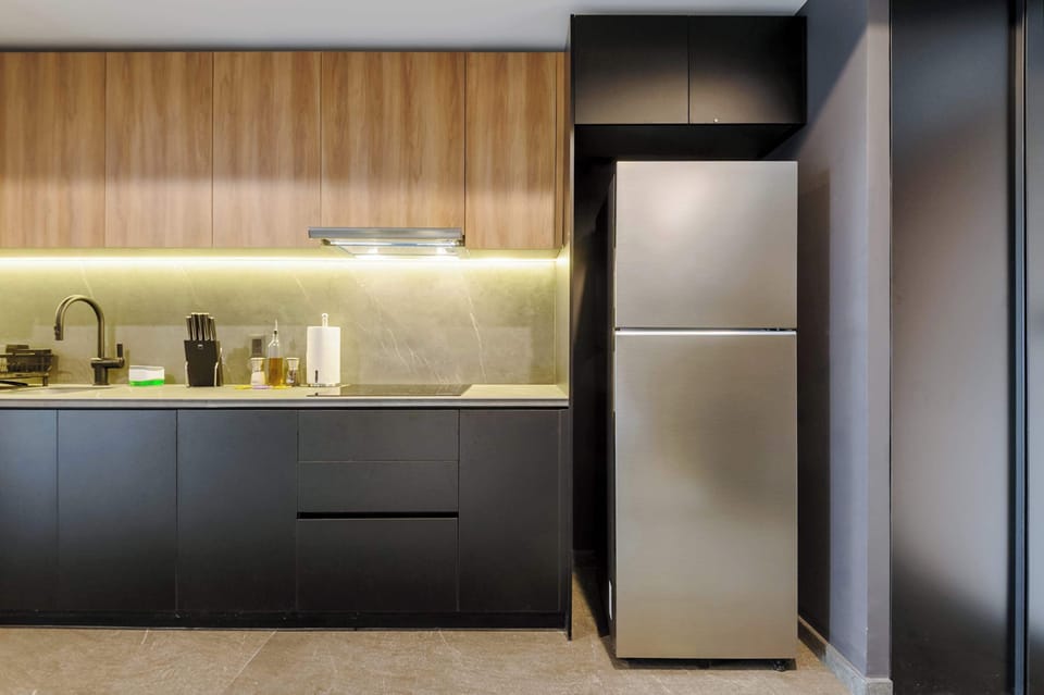 Fully equipped kitchen featuring modern appliances, a full-size refrigerator, and everything needed for home cooking.
