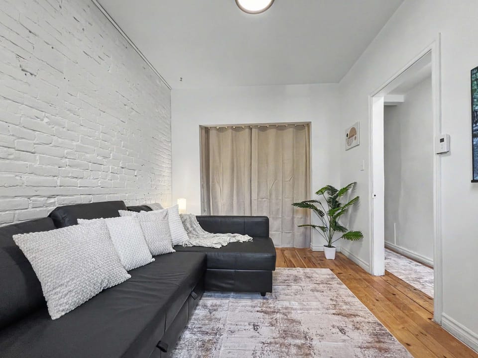 Relax in style! Our airy living room blends rustic brick charm with modern comfort—the perfect spot for movie night.
