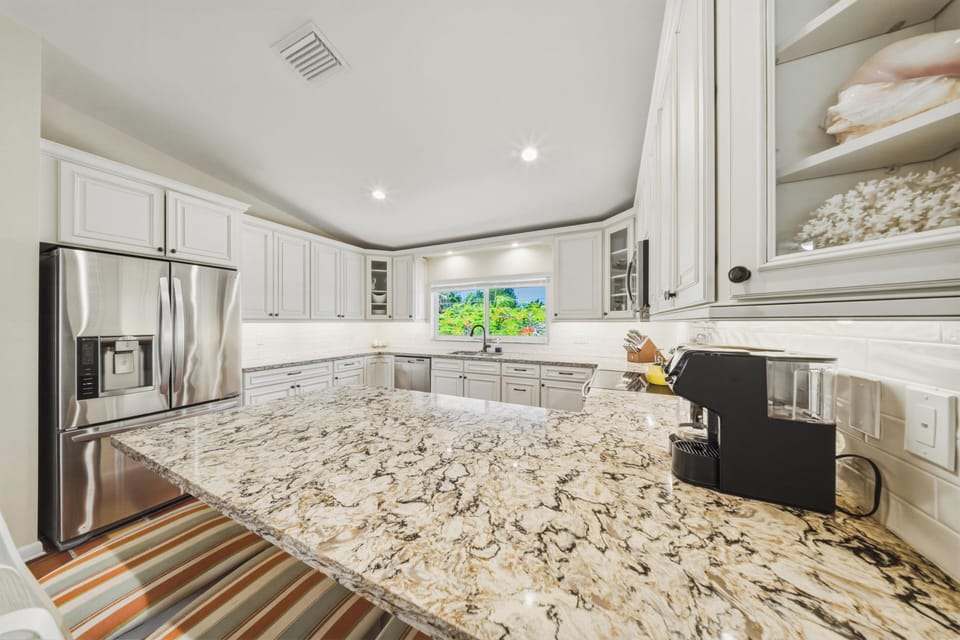 Fully equipped modern kitchen with waterfront views in a luxury Marathon FL vacation rental. This open-layout space connects to the dining room, making it ideal for guests seeking a Florida Keys waterfront home with pool.
