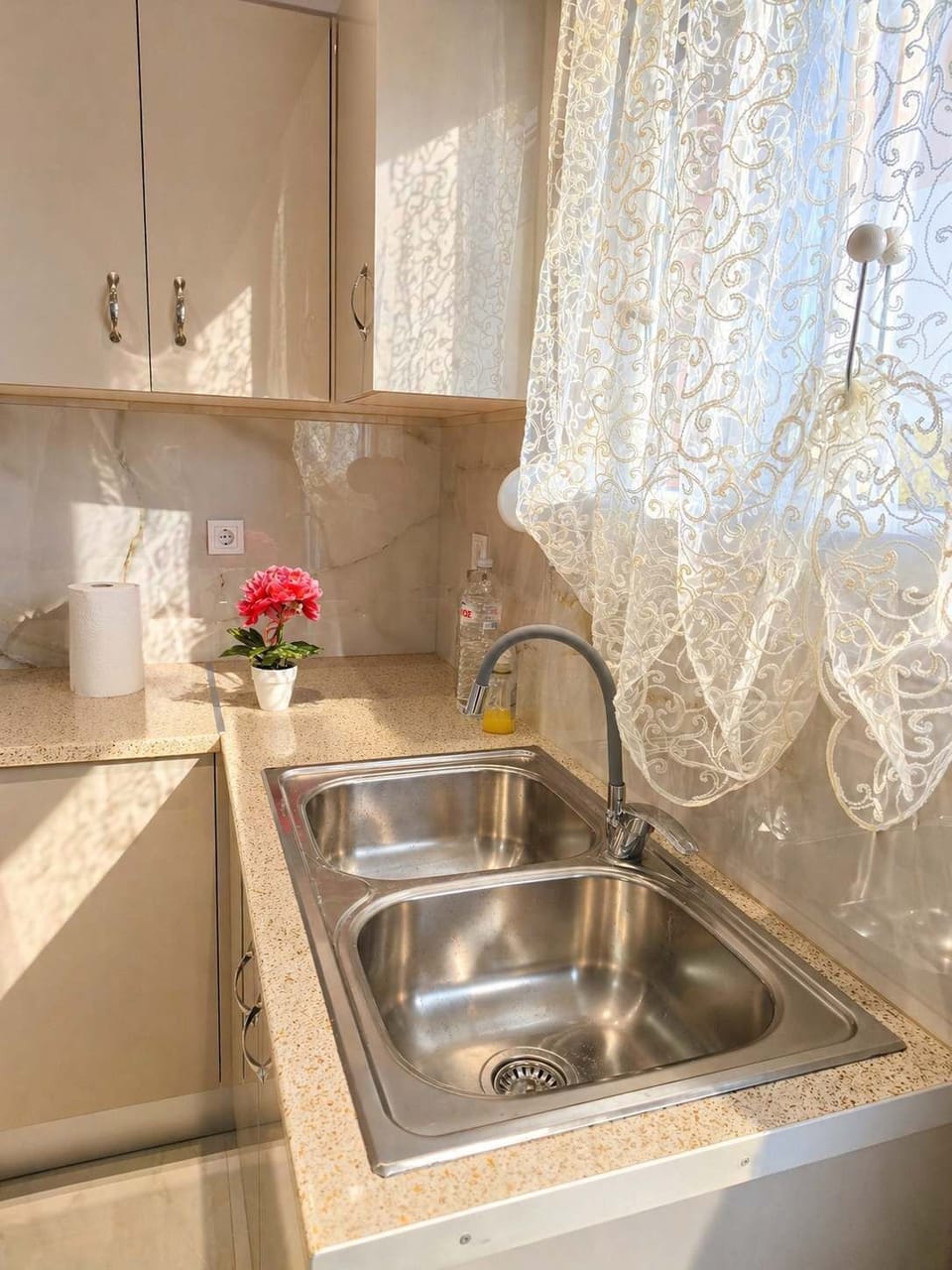 The kitchen sink area with natural light coming through the window, part of a fully equipped space for preparing meals during your stay.