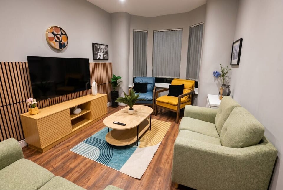 Light-filled living room with bold colours and plenty of seating for the whole group.