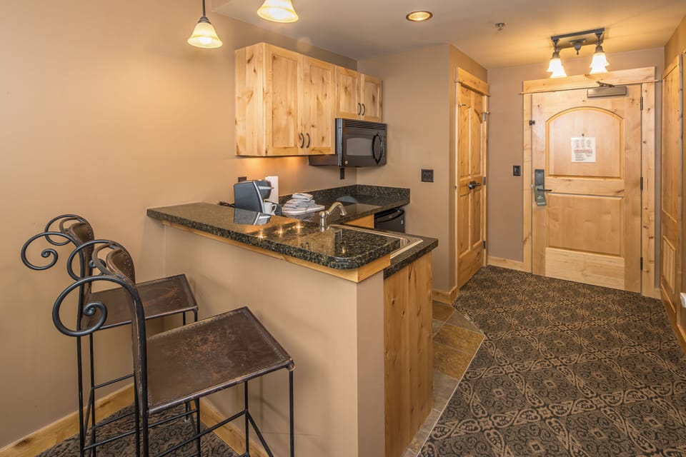 Kitchenette with bar seating and entryway area I Main Level