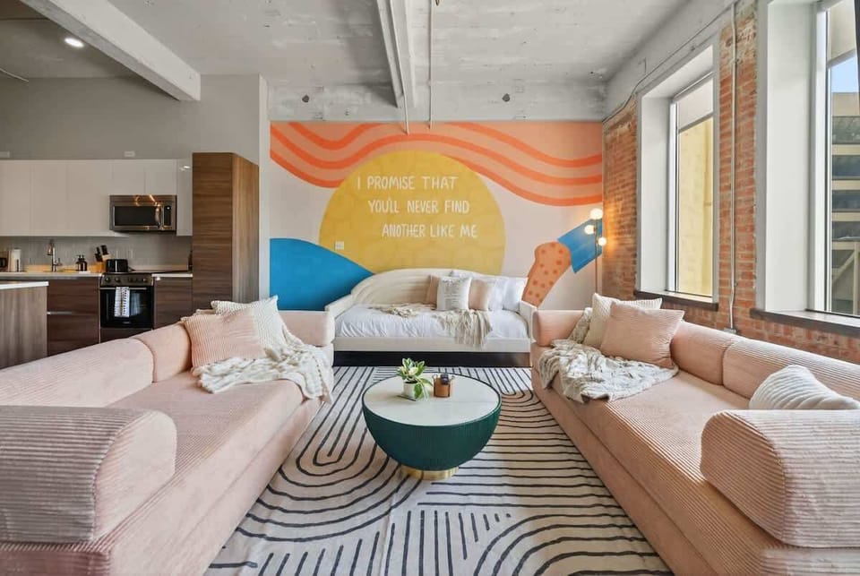 Lounge in Lyrics – blush sofas, big windows, and a mural declaring: “I promise that you’ll never find another like me.”