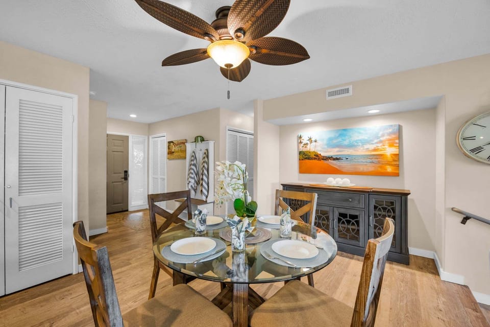 This welcoming dining area offers ample seating and a relaxed atmosphere accented by coastal artwork