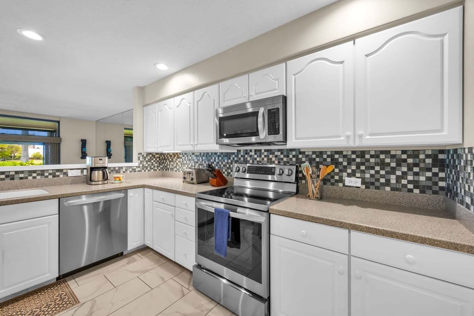 This open kitchen setup features stainless appliances and ample counters for stress‑free meal preparation