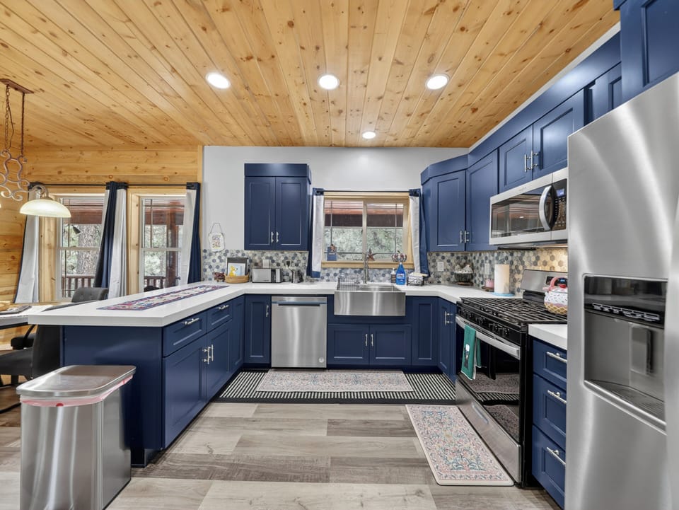 Your fully equipped kitchen features stainless steel appliances, a spacious island, and a charming wood-paneled ceiling—perfect for preparing memorable meals during your stay.