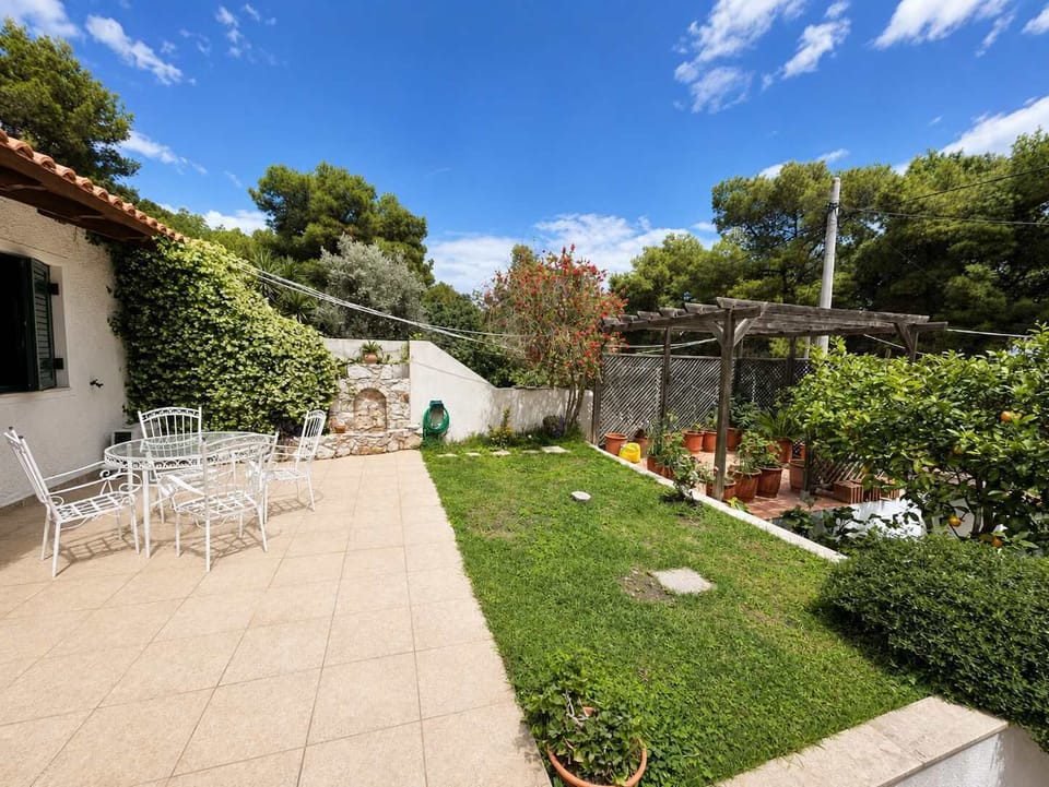 Spacious outdoor terrace and garden surrounded by trees and sunshine, perfect for outdoor dining, relaxing afternoons and peaceful evenings