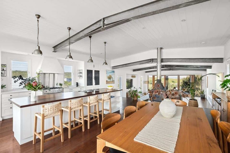 The open-plan layout flows seamlessly from kitchen to dining and living, creating an easy rhythm for entertaining and relaxed coastal living.