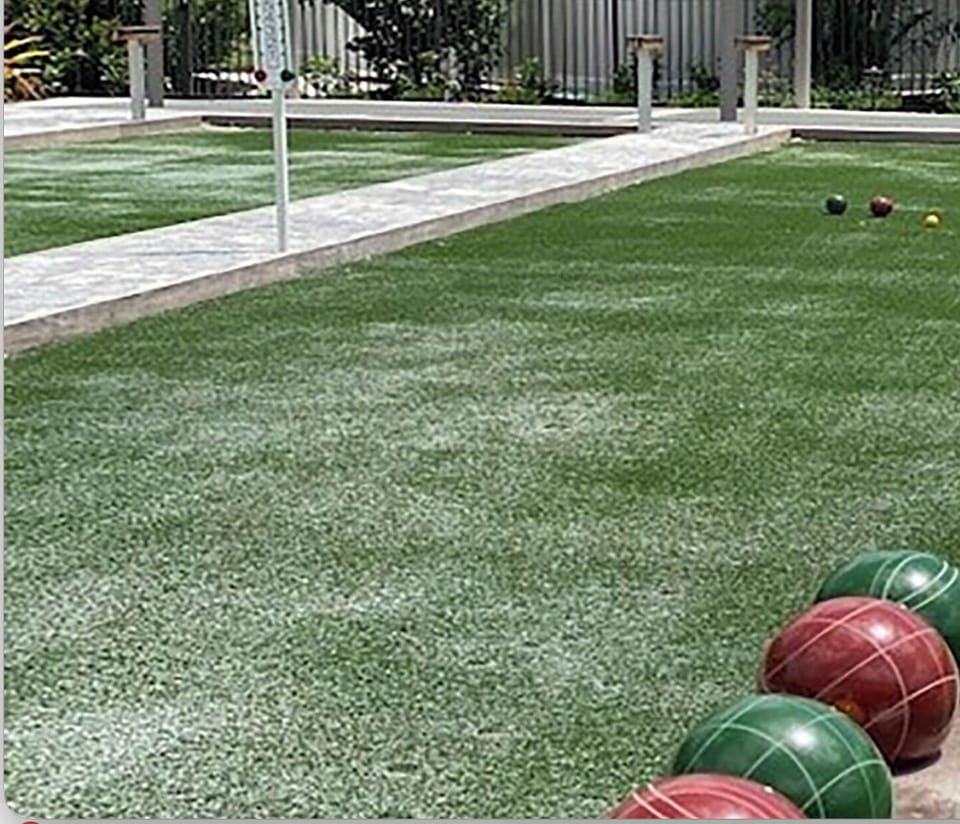 A dedicated bocce ball court awaits with smooth synthetic turf and classic colored balls ready for your friendly matches in the sunshine.