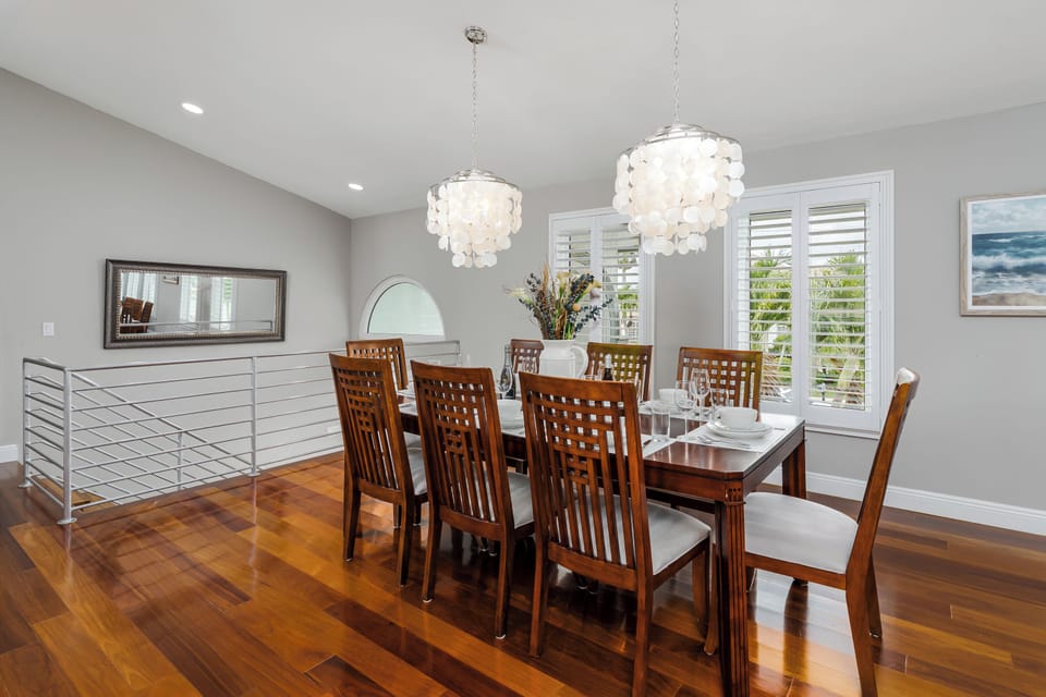 Gather around this elegant dining table where warm wood tones and cascading chandeliers set the stage for memorable meals together during your stay.
