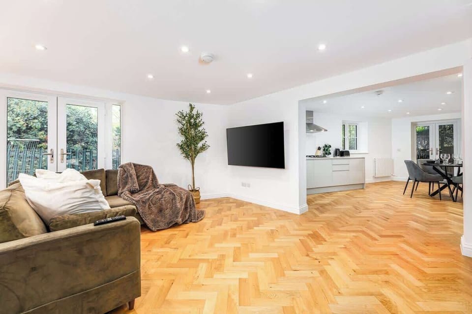 Warm herringbone wood floors + modern decor set the scene for comfort, whether you're working from home or streaming on the 65in smart TV.