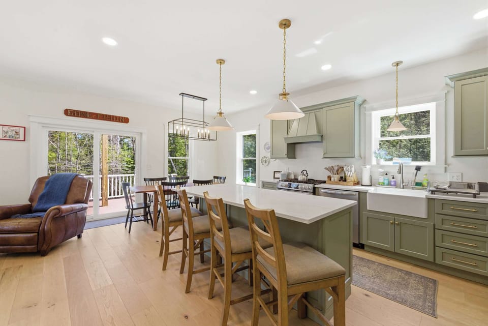 The open-concept main level flows from the designer kitchen straight through to the dining area and out to the covered deck.