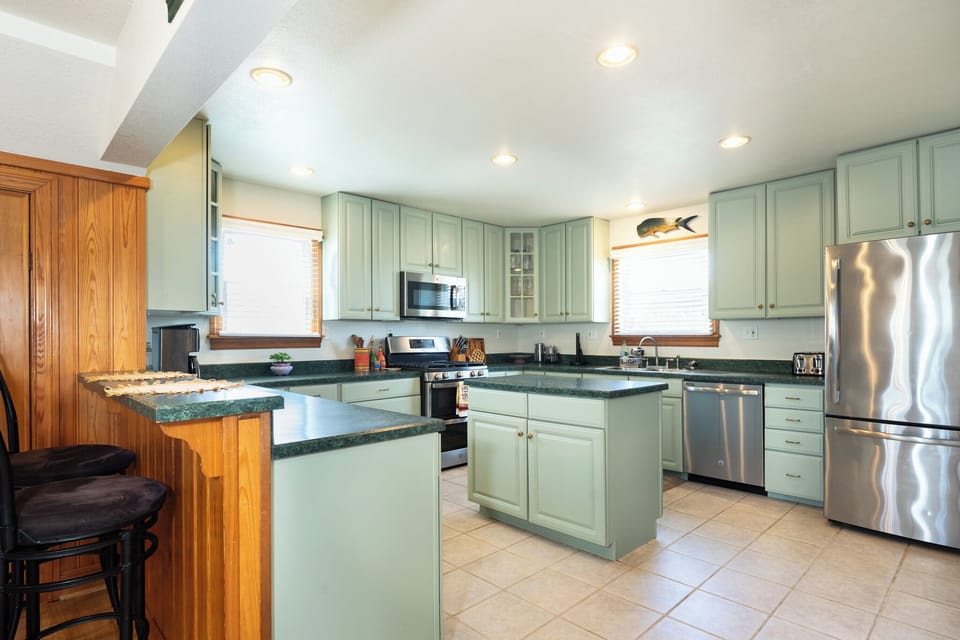 Cook together in this spacious kitchen with premium appliances, granite counters, and plenty of room to gather. Natural light and coastal charm create a welcoming space for your vacation meals.