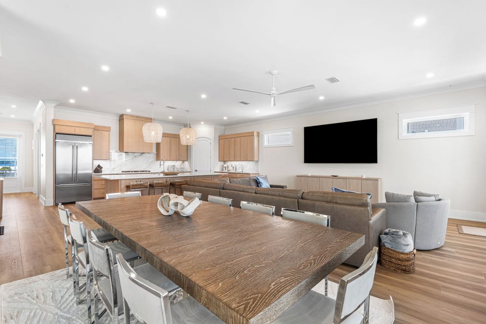 Gather around this spacious open-plan living area, where natural wood tones and modern finishes create a welcoming atmosphere perfect for sharing meals and making memories with your travel companions.