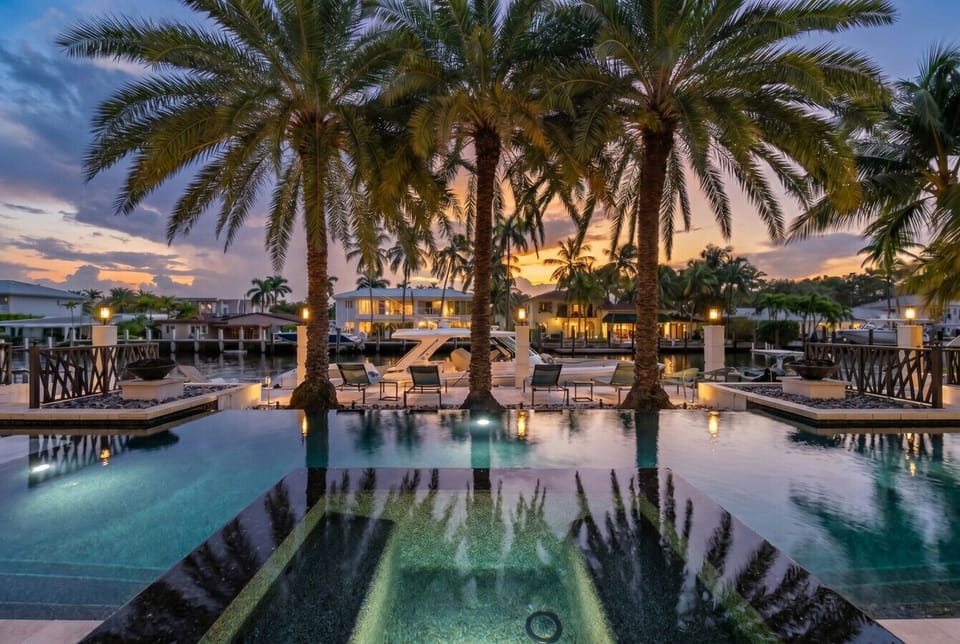 Outdoor living space offers a pristine swimming pool, integrated spa and private dock with lounging areas