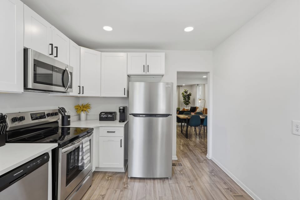 Bright modern kitchen with stainless steel appliances and dining access