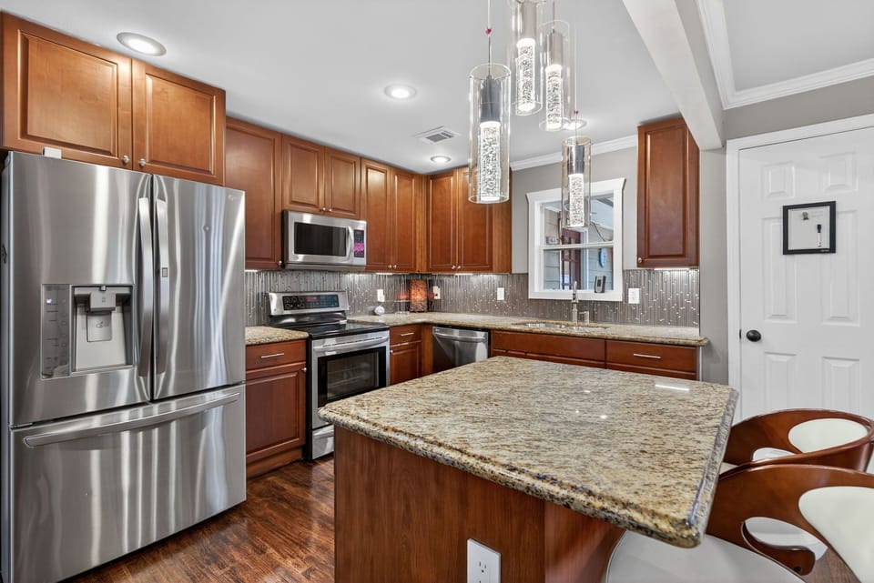 Modern kitchen w/ granite counters, stainless appliances & inviting island