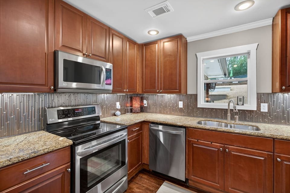 Chef’s kitchen w/ stainless steel appliances, modern finishes & ample prep space