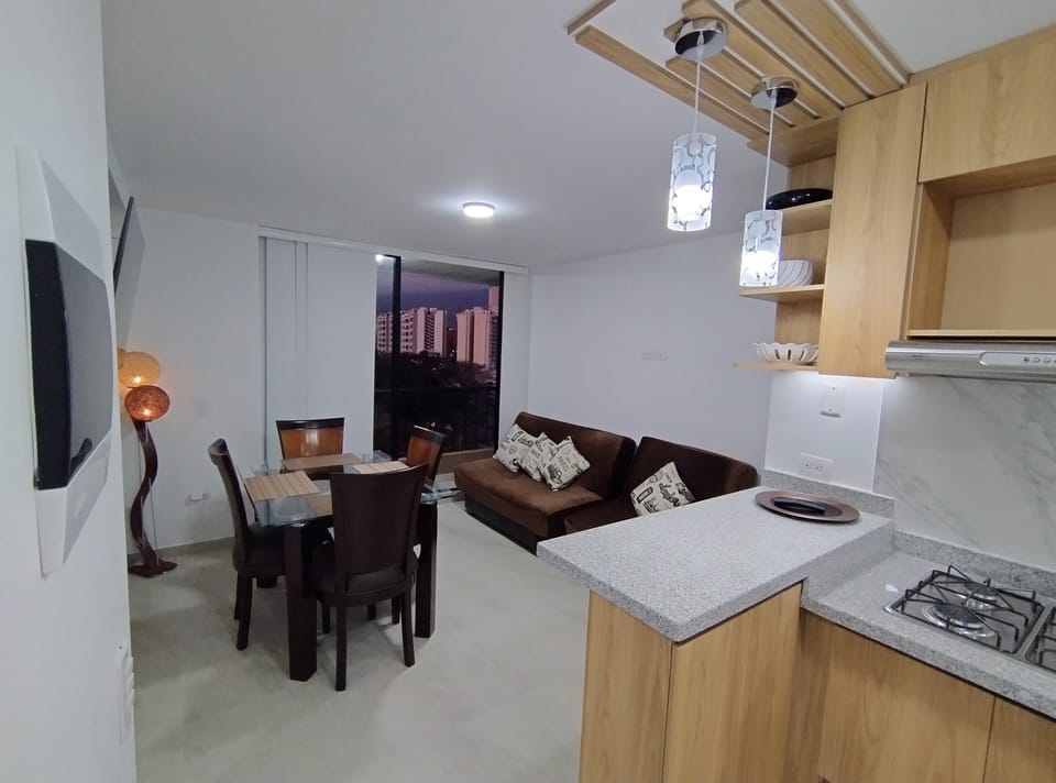 Open kitchen, dining and living area with warm light and city views.