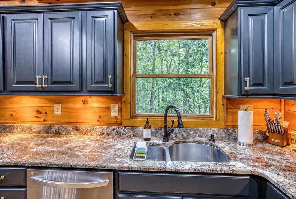 Enjoy a kitchen with a view! Make use of the spacious granite countertops and deep stainless steel sink, perfectly positioned under a window that looks out onto the lush, green woods.