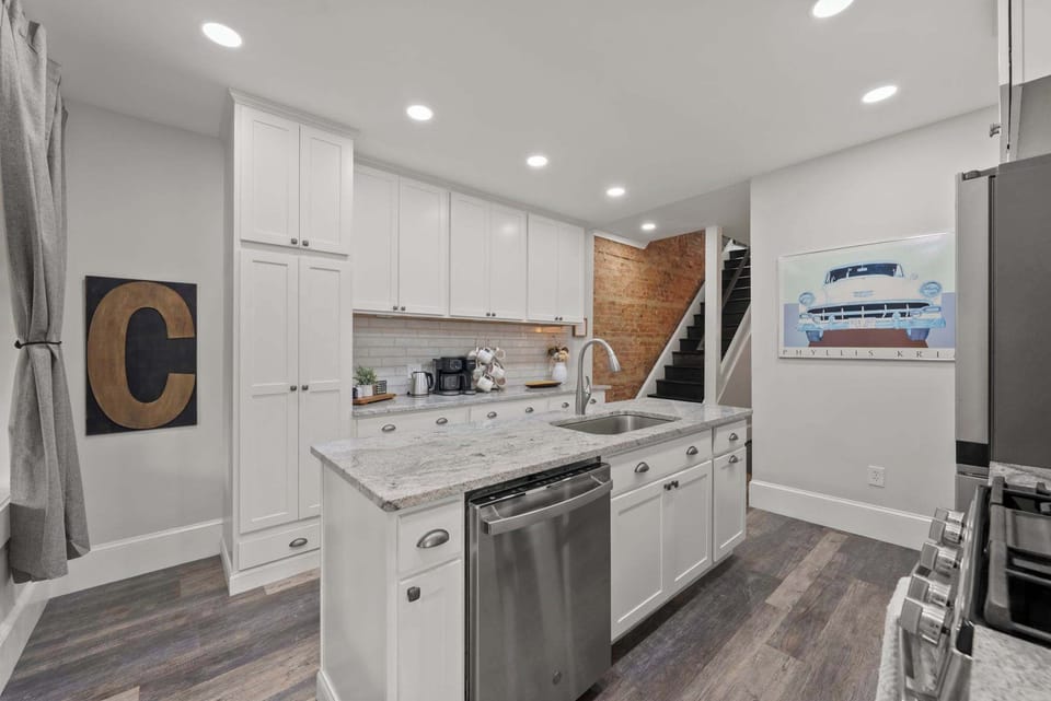 Whip up breakfast in the sleek white kitchen w/ island & pendant lighting.