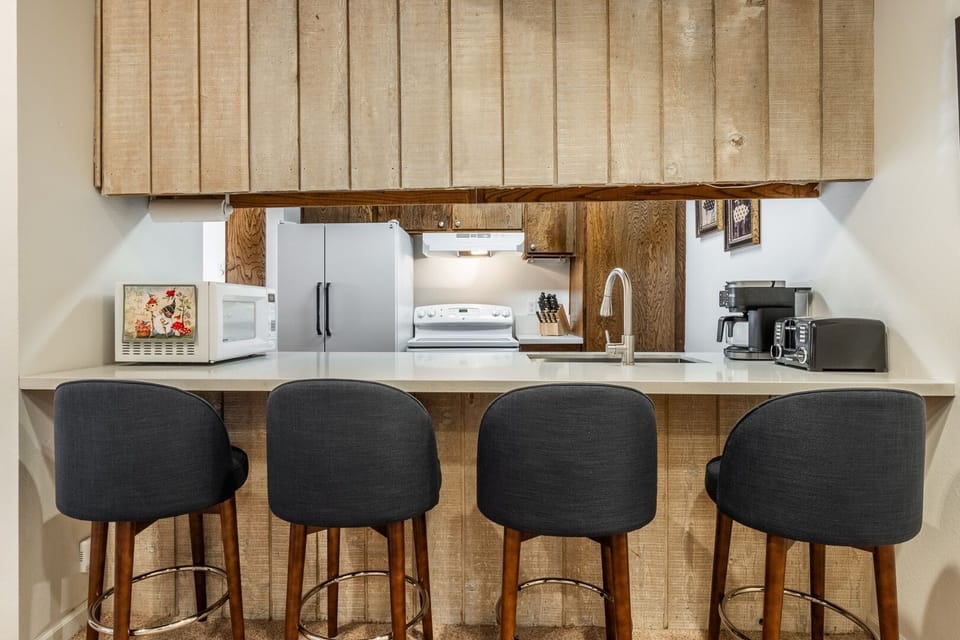 Cozy kitchen with breakfast bar seating for four and full essentials