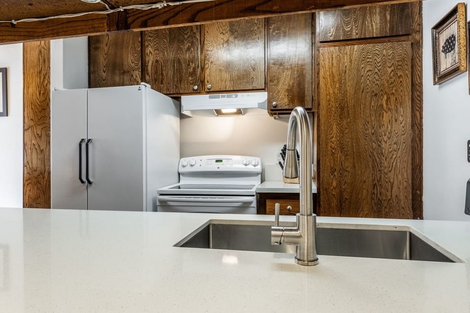 Bright kitchen with large island, modern sink, and rustic wood charm