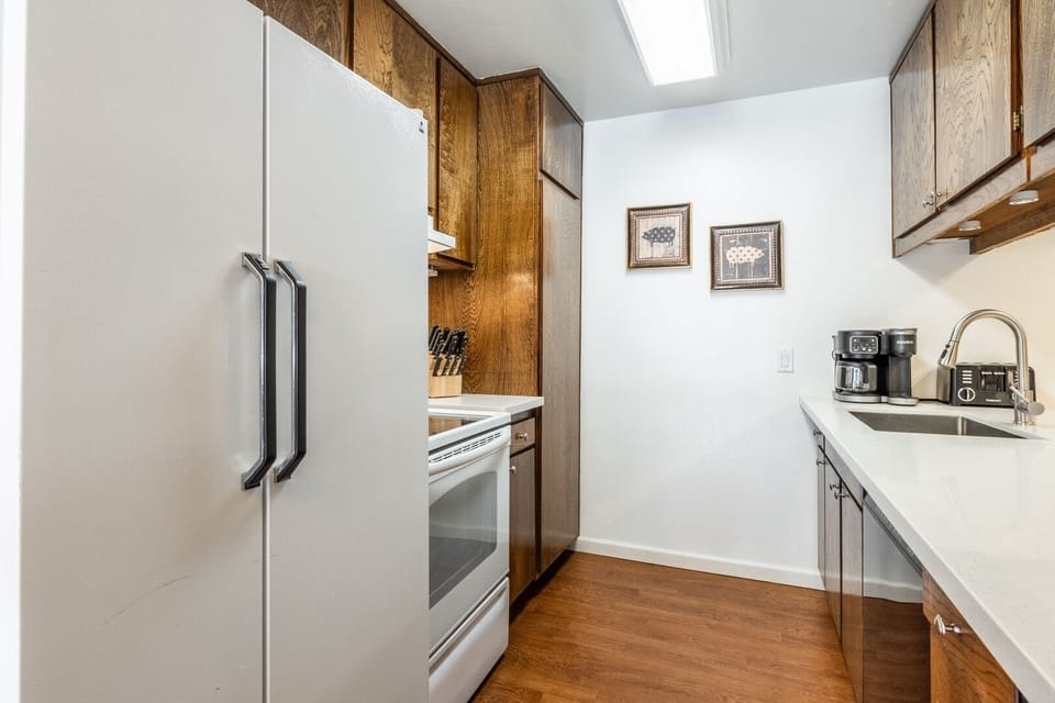 Bright galley kitchen with full-size appliances and coffee station