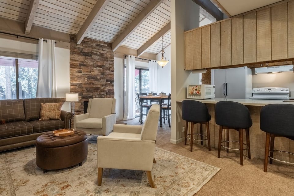 Cozy open living space with vaulted ceilings, breakfast bar, and dining area