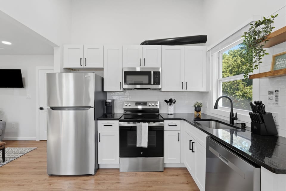 Bright modern kitchen with stainless appliances and sunny window views
