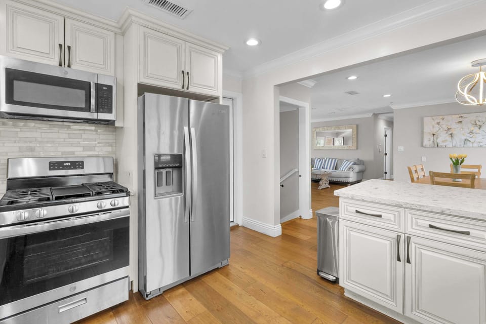 Kitchen showing stainless steel appliances with open layout to dining area and living room