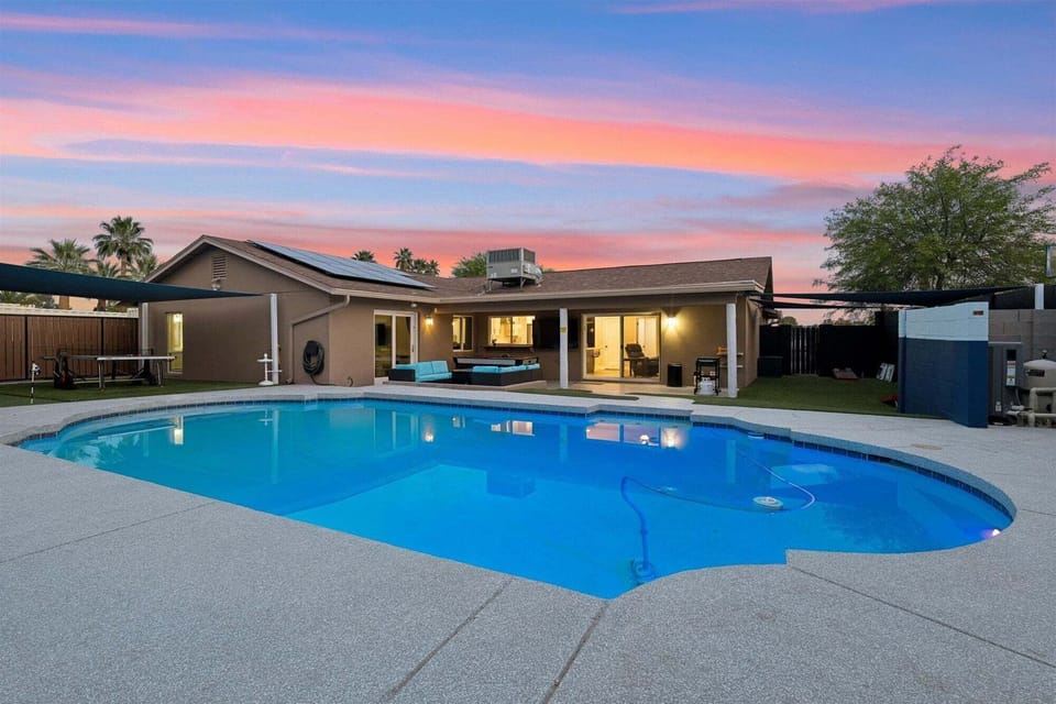 Complete with a fenced yard, private pool, covered patio, grill, firepit, cornhole, air hockey, pool table, mini golf putting green, and ping pong table.