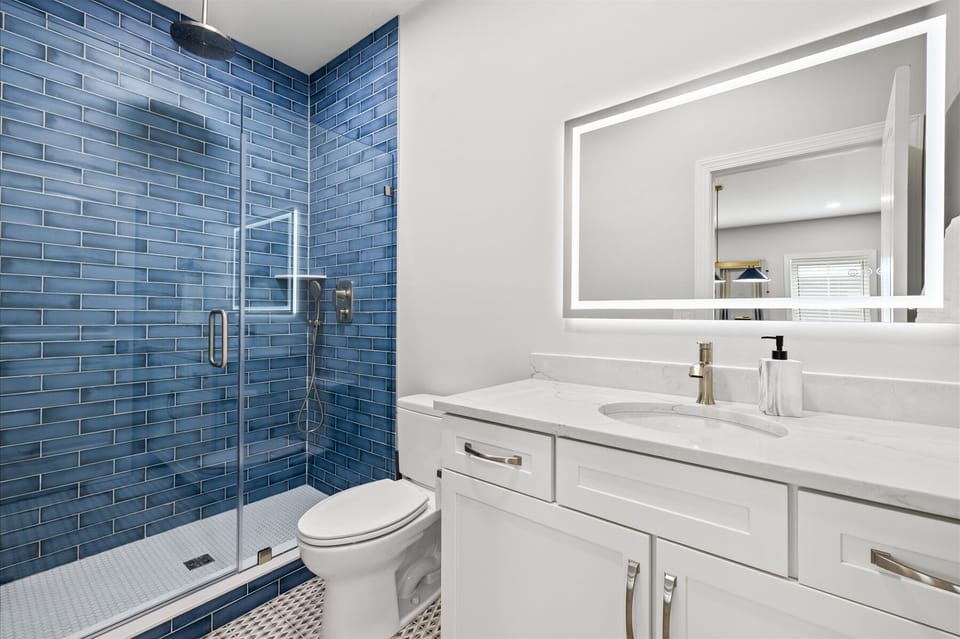 1st Level Hall Bathroom with Stunning Tile, Seamless Shower Door, and Dual Shower