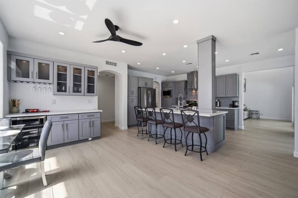 Fully stocked kitchen with island seating and open dining area.