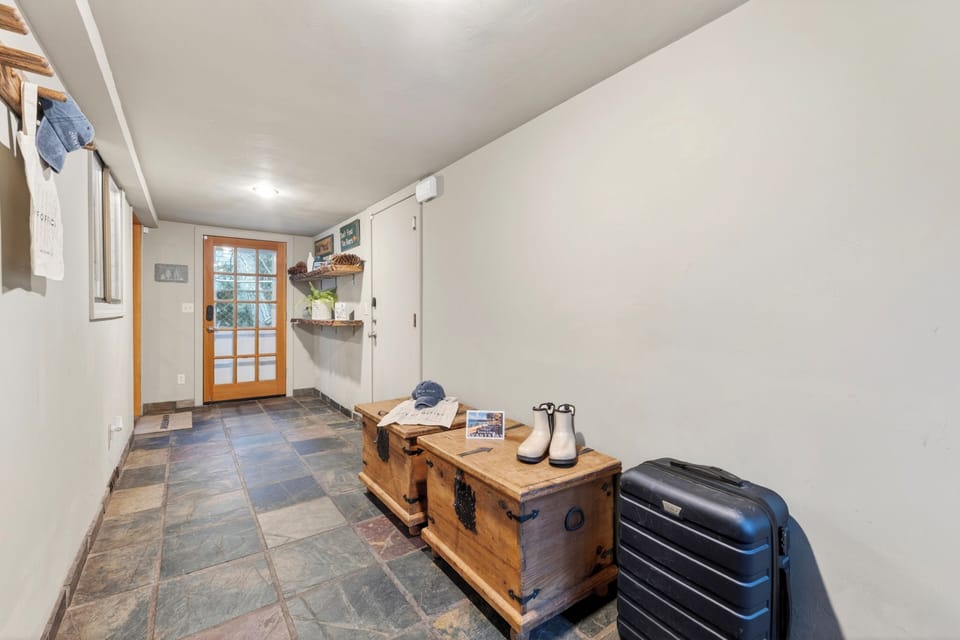 Welcoming entryway with rustic decor, storage bench, and ample space.
