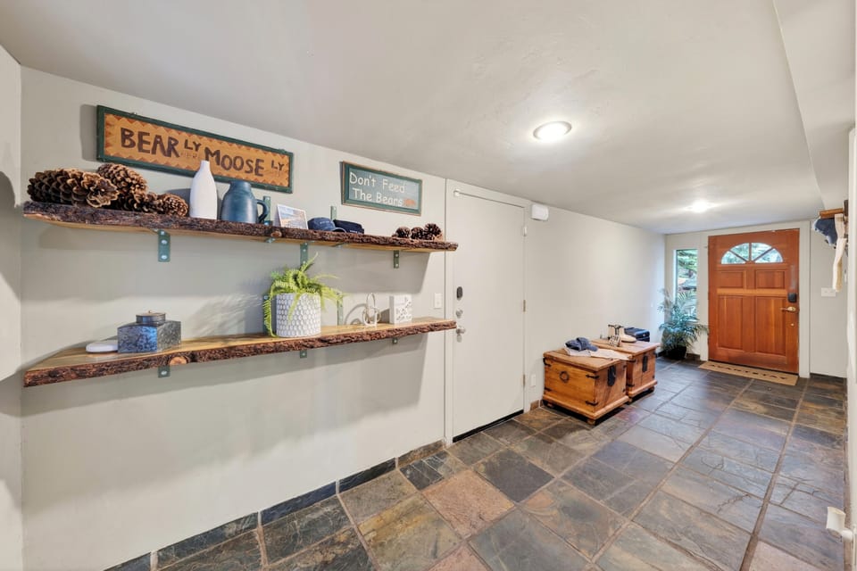 Welcoming entryway with rustic decor, storage bench, and ample space.