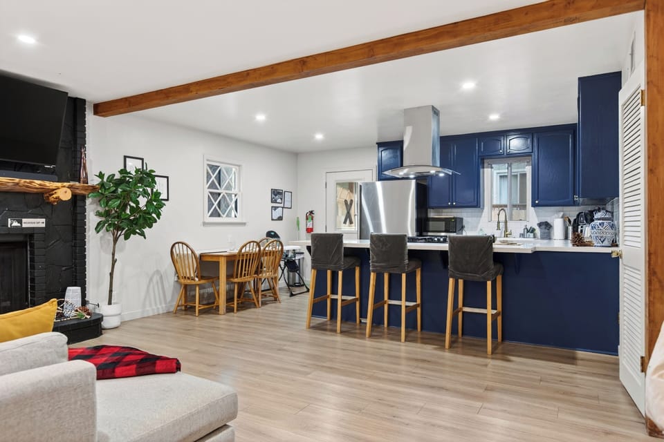 Gather around the bold blue kitchen with bar seating, stainless steel appliances, and an open layout designed for easy group living.