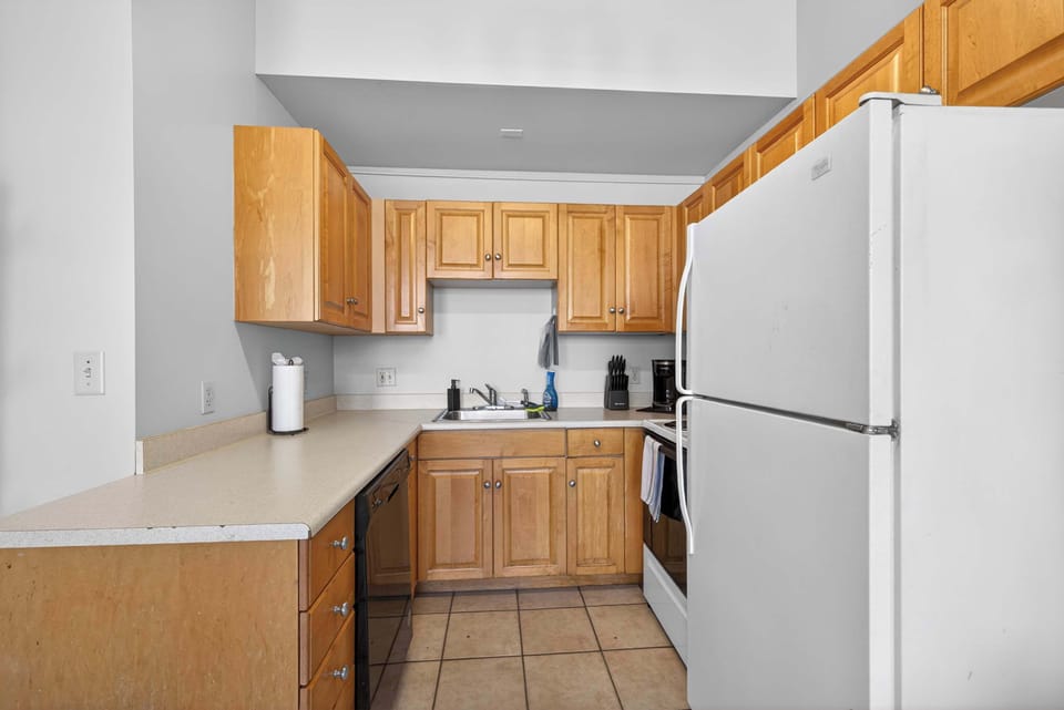 Compact kitchen w/ wood cabinets, full-size appliances & efficient prep space