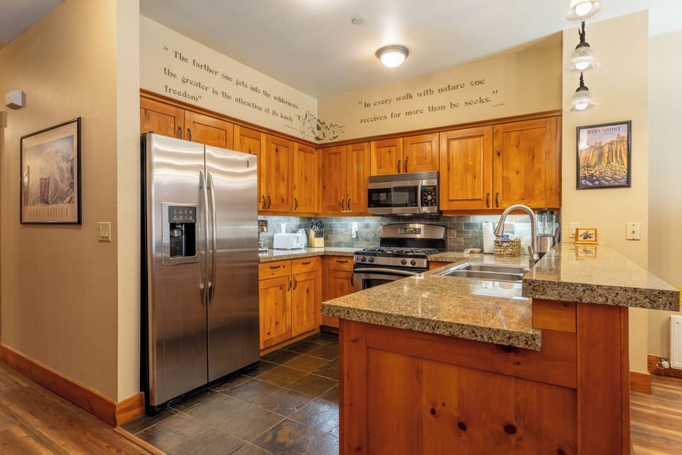 Fully stocked kitchen w/ solid stone countertops.