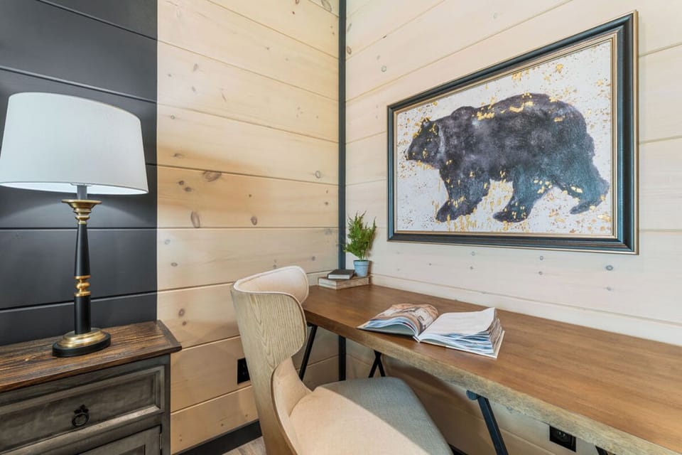 Your private workspace awaits with rustic wood walls and inspiring mountain wildlife art to spark creativity during your stay.