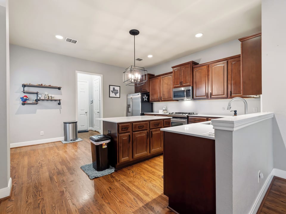 Picture yourself preparing your favorite meals in this fully equipped kitchen, with rich cabinetry, modern appliances, and ample counter space for your culinary adventures.
