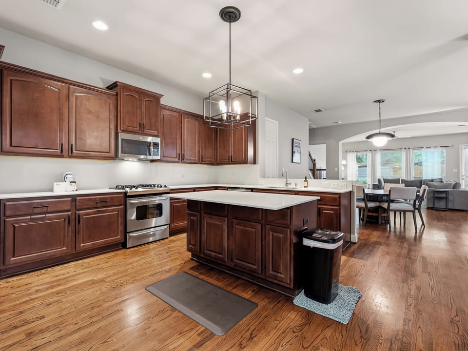 You'll love preparing meals in this spacious, well-appointed kitchen featuring rich wood cabinetry, modern appliances, and a generous island—perfect for gathering and creating memorable moments during your stay.