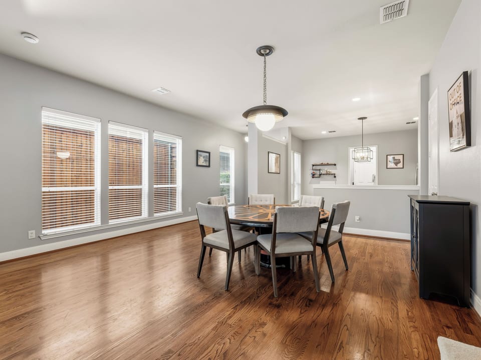 Picture yourself gathered around this beautiful dining table, bathed in natural light from expansive windows. The open flow to the kitchen makes hosting effortless, while rich hardwood floors add warmth throughout your space.