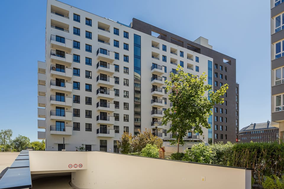 Modern apartment building with spacious balconies and beautifully maintained surroundings.