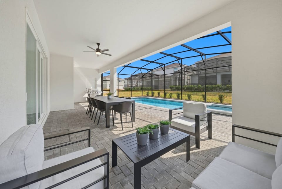Step outside to your private oasis, where sleek outdoor furniture complements the spacious patio overlooking a sparkling pool. The screened enclosure allows for comfortable relaxation while enjoying the gentle breeze and sunshine.