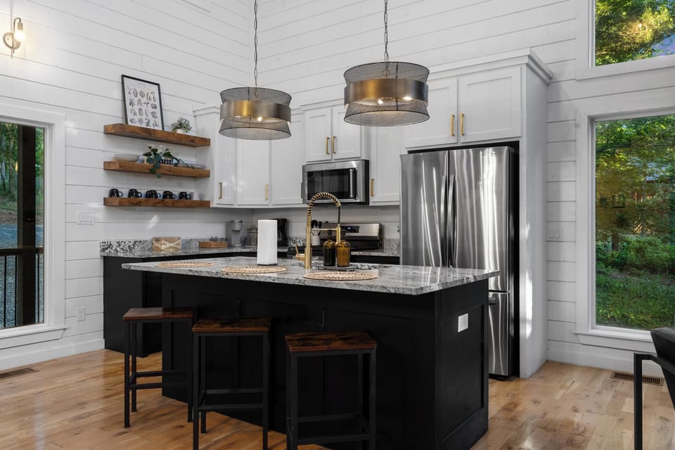 A functional kitchen space with sink, cookware, and dinnerware provided, making it simple to cook, serve, and enjoy meals at the cabin